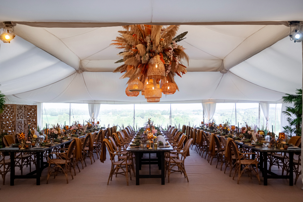 Unusual wedding marquee with cool rustic decor and furniture for an outdoor dinner party with 200 guests