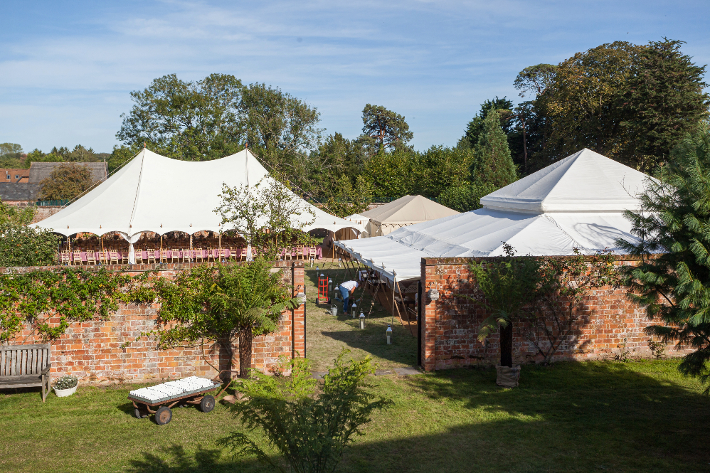 Huge outdoor wedding with multiple marquees for dining and dancing in a secret walled garden in the English countryside for a luxury weekend long wedding